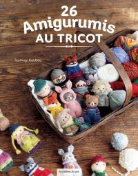 Couverture avant d'un livre de loisirs créatifs intitulé « 26 Amigurumis AU TRICOT ». La couverture présente une photographie close-up et chaleureuse d'un panier en bois rustique débordant de nombreux petits personnages et animaux en peluche tricotés (ami