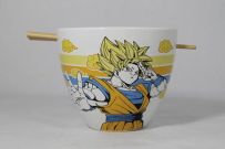 Bol à ramen blanc Dragon Ball Z avec illustration de Goku en Super Saiyan. On voit les baguettes en bois insérées horizontalement à travers les encoches. Un accessoire de cuisine manga.