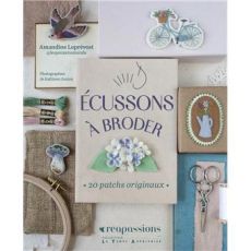 Mise en scène de la couverture du livre "Écussons à broder" entourée d'accessoires de couture (fils, ciseaux, tambour) et de superbes écussons brodés (oiseau, vélo, champignon).