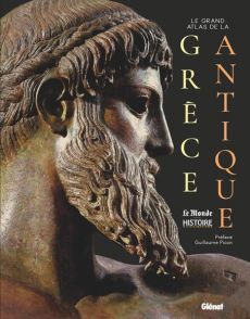 Couverture du livre "Le Grand Atlas de la Grèce Antique", coédité par Glénat et Le Monde Histoire & Civilisations. Sur un fond noir élégant, on observe en gros plan et de profil le visage majestueux d'une statue antique en bronze représentant un dieu grec